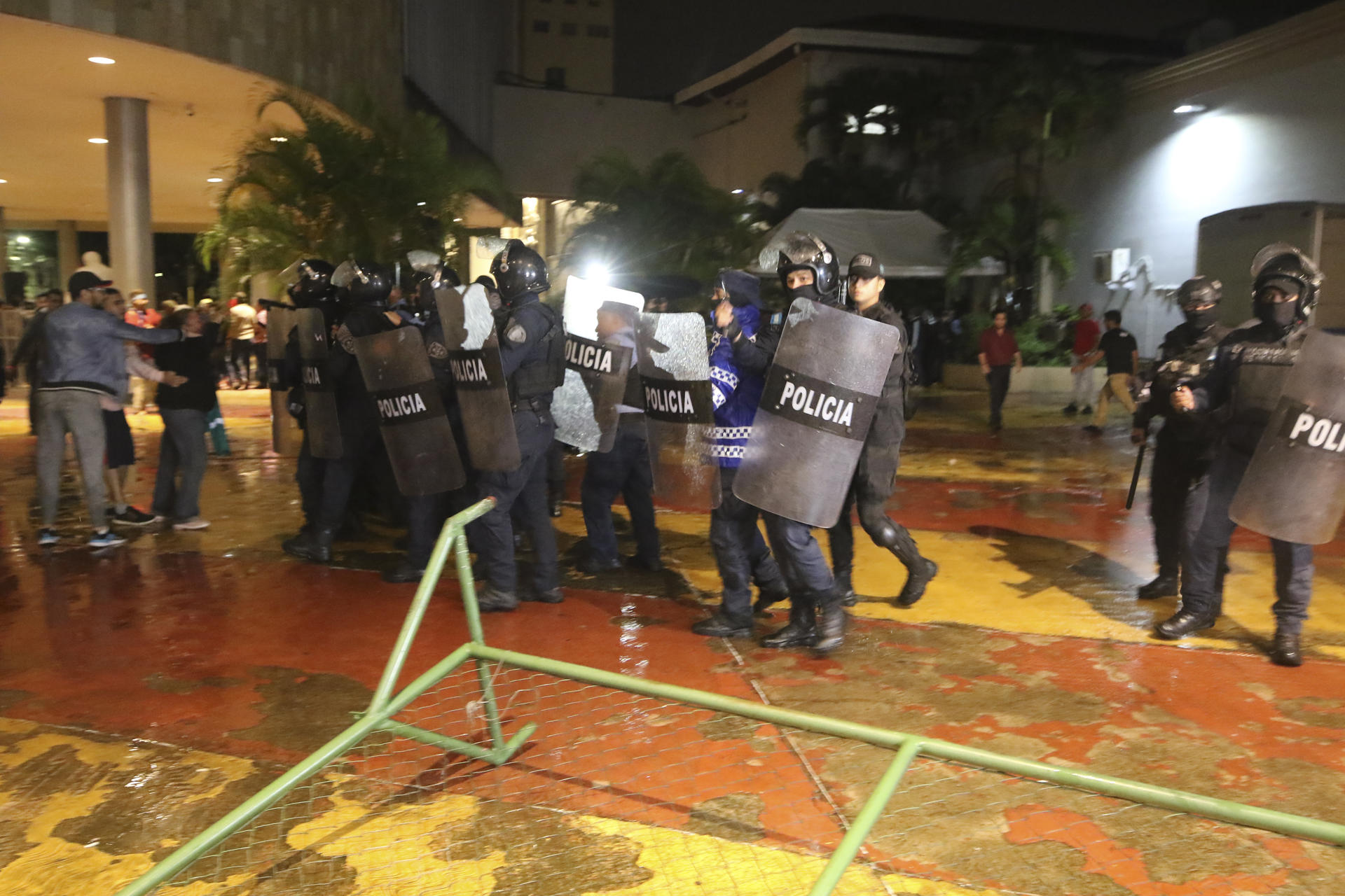 Miembros de la Policía se enfrentan con simpatizantes del gobernante Partido Libertad y Refundación (Libre) hoy, en el Congreso Nacional en Tegucigalpa (Honduras). Varias personas, entre diputados y periodistas, entre otras, resultaron lesionadas esta noche en la planta baja del Parlamento de Honduras, donde se registran incidentes violentos, mientras las principales fuerzas de oposición exigen que se convoque a una sesión ordinaria. EFE/ Stringer
