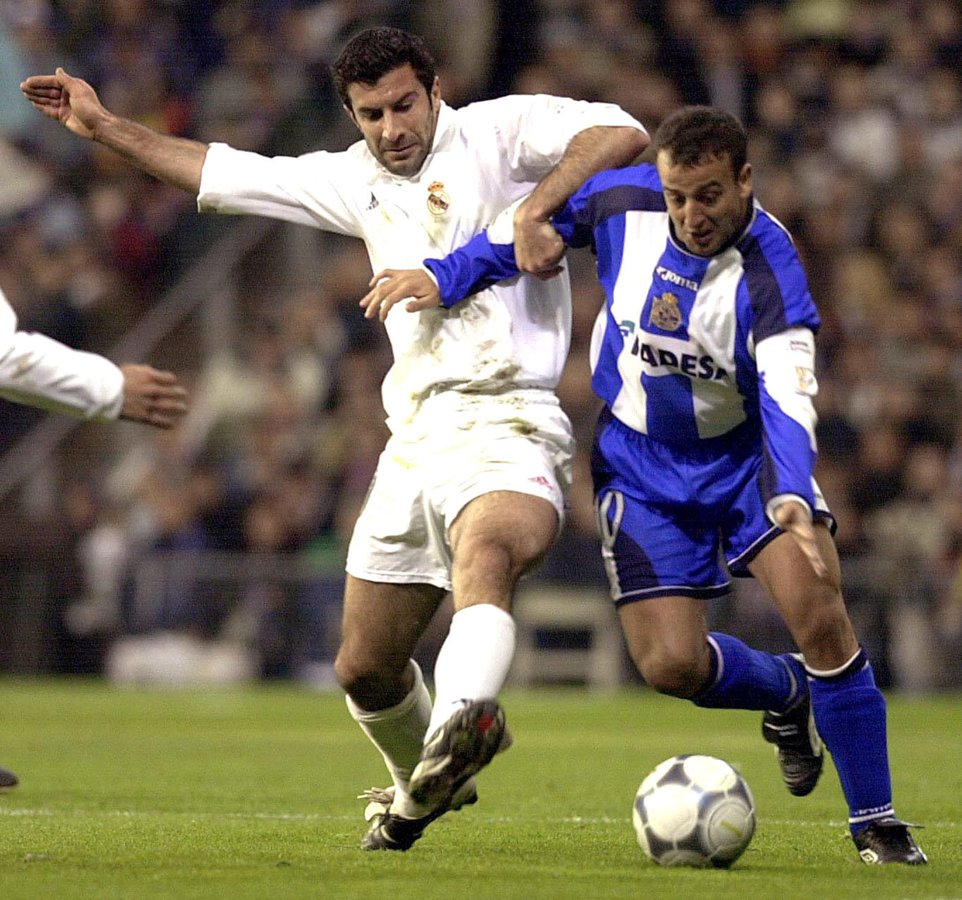 Imagen de archivo del excentrocampista del Deportivo de La Coruña Francisco Javier González "Fran" (d), que se lleva el balón a pesar de ser agarrado por el jugador del Real Madrid Luis Figo. EFE/SERGIO BARRENECHEA
