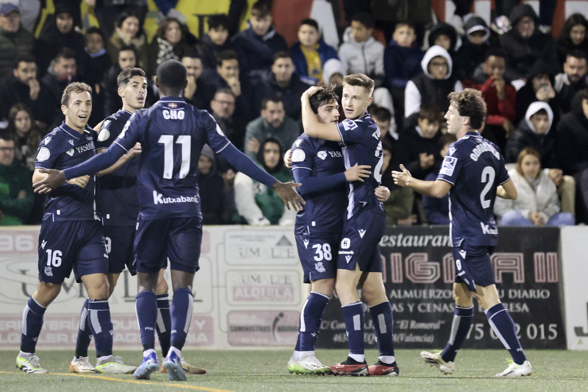 El jugador de la Real Sociedad, Carlos Fernadez (2º izq), autor del 0-1, celebra con sus compañeros el gol marcado al CD Buñol durante el partido correspondiente a la Copa del Rey jugado en el estadio Tomás Berlanga de Requena, (Valencia) .EFE/ Ana Escobar
