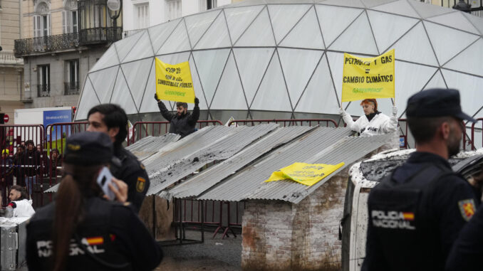 Activistas de Greenpeace han esparcido este miércoles en la madrileña Puerta del Sol restos de enseres y otros objetos destruidos por las danas (depresiones aisladas en niveles altos) que azotaron Madrid y Toledo meses atrás para denunciar que los combustibles fósiles destruyen el clima. EFE/ Borja Sanchez-trillo
