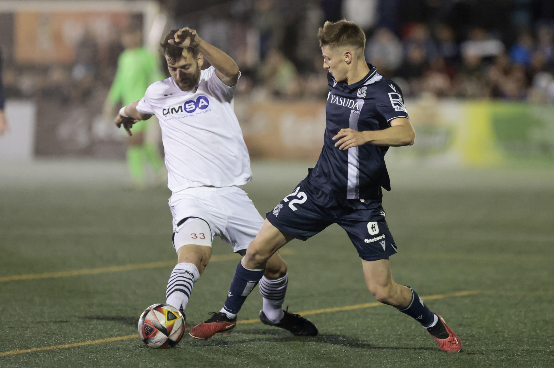 El jugador de la Real Sociedad, Beñat Turrientes (d) ,junto a Duco (i) del CD Buñol durante el partido correspondiente a la Copa del Rey jugado en el estadio Tomás Berlanga de Requena, (Valencia) .EFE/ Ana Escobar
