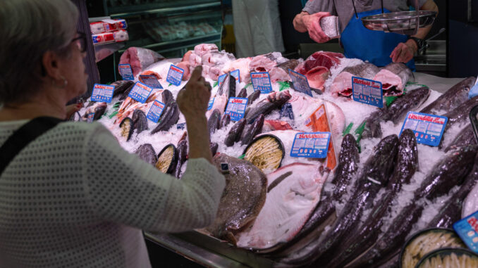 Una mujer compra en una pescadería en un mercado de Madrid. EFE/ Daniel González
