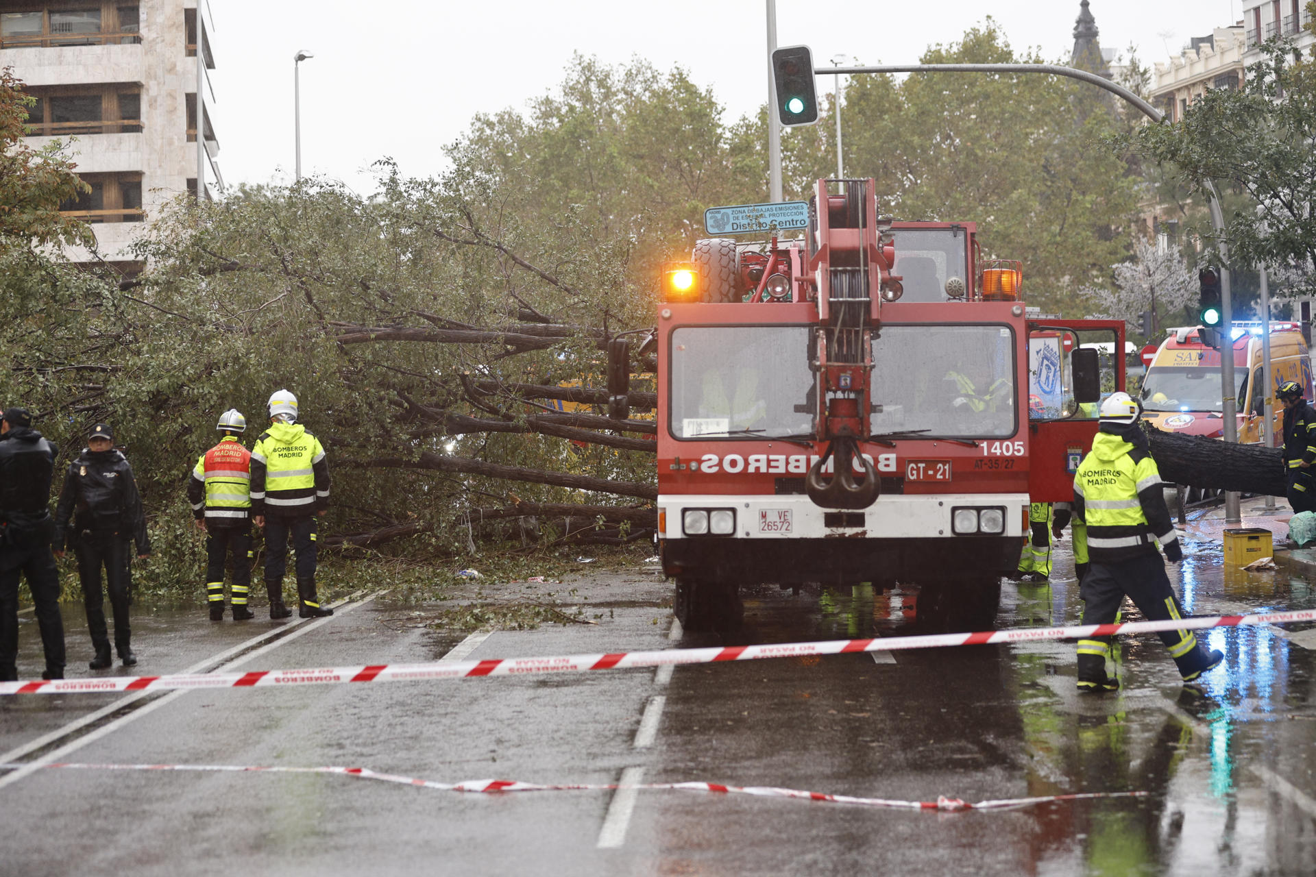 Efectivos del cuerpo de bomberos permanecen en el número 1 de la calle Almagro de Madrid, donde este jueves una mujer de 23 años ha fallecido tras caerle un árbol encima a causa de las fuertes rachas de viento, cuando cruzaba por un paso de cebra. EFE/ Rodrigo Jimenez
