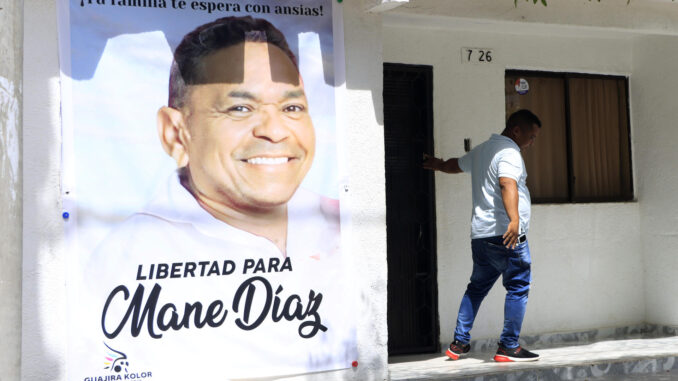 Una persona sale hoy de la casa familiar del futbolista colombiano Luis Díaz, de donde cuelga un gran cartel con la imagen de su padre, Luis Manuel Díaz, secuestrado el pasado sábado, en Barrancas, departamento de La Guajira (Colombia). EFE/Ricardo Maldonado Rozo
