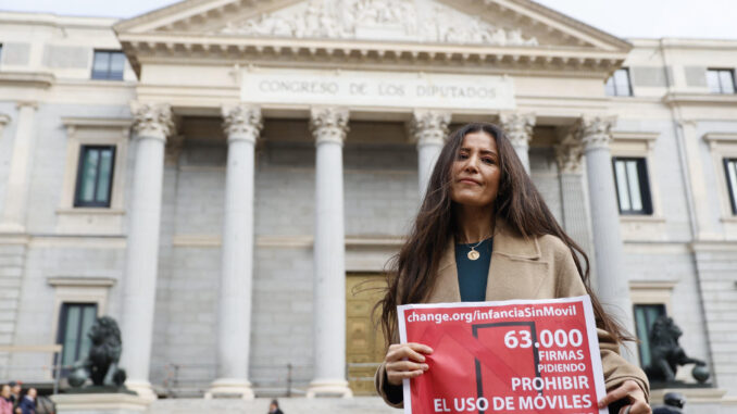 Ángela Sánchez-Pérez Merino, docente de la comunidad de Madrid, posa frente al Congreso de los Diputados para presentar la lista de firmas recogidas para una campaña de regulación de los teléfonos móviles en menores, que ha organizado junto a otra decente de secundaria, este jueves en Madrid. EFE/ Mariscal
