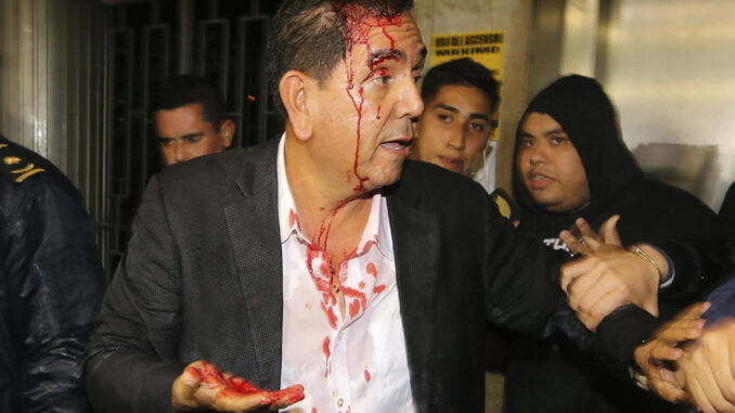 El diputado por el Partido Nacional Antonio Rivera es resguardado después de ser agredido por simpatizantes del gobernante Partido Libertad y Refundación (Libre) hoy, en el Congreso Nacional en Tegucigalpa (Honduras).  EFE/ Stringer
