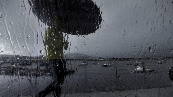 Un hombre con paraguas camina este lunes por el puerto de Pontedeume, en A Coruña. EFE/ Cabalar
