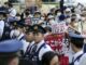 Agentes de policía vigilan mientras manifestantes con pancartas en solidaridad con el pueblo palestino protestan contra "la masacre de Israel en Gaza" y el comercio de armas, cerca de la Iikura Guest House del Ministerio de Exteriores en Tokio, donde se celebra una reunión de ministros de Exteriores del G7, el 7 de noviembre de 2023. EFE/EPA/KIMIMASA MAYAMA