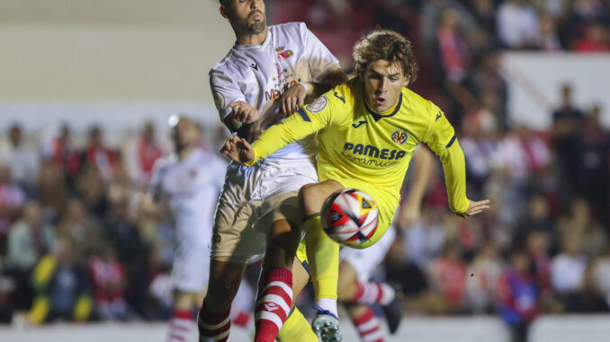 CHICLANA DE LA FRONTERA (CÁDIZ), 02/11/2023.- El centrocampista del Chiclana, David Montero (i), disputa el balón con Jorge Pascual (d), delantero del Villarreal, durante el partido de primera ronda de Copa del Rey entre Chiclana CF y Villarreal CF, este jueves en el Campo Municipal de Chiclana, en Chiclana de la Frontera. EFE/Román Ríos
