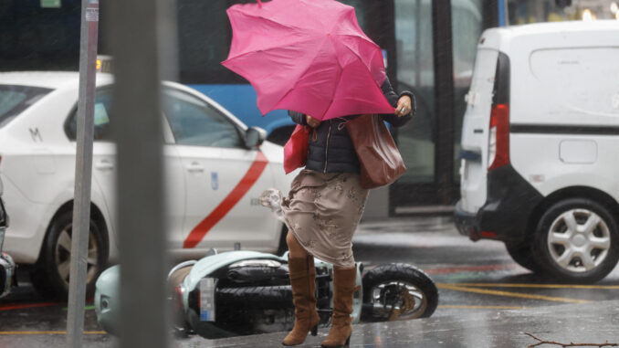 Una viandante se enfrenta a las fuertes rachas de viento mientras camina por una calle del centro de Madrid este jueves. EFE/ Juan Carlos Hidalgo
