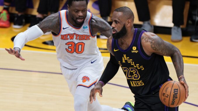 El juagador de los Angeles Lakers LeBron James (d) regatea el balón pasando por Julius Randle de los New York Knicks durante la primera mitad del partido de baloncesto de la NBA.EFE/EPA/ALLISON CENA
