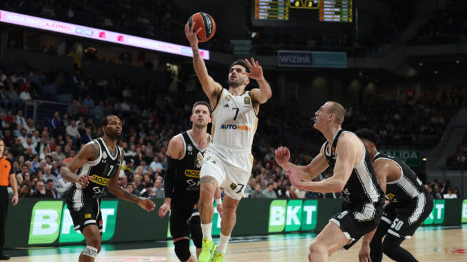 El base argentino del Real Madrid Facundo Campazzo (c) entra a canasta, durante el partido de la jornada 16 de la EuroLiga que Real Madrid y Partizán de Belgrado disputaron en el WiZink Center, en Madrid. EFE/Kiko Huesca
