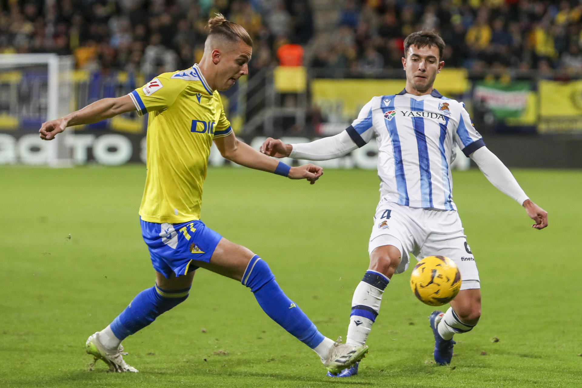 El centrocampista del Real Sociedad Zubimendi (d) lucha por el balón con el delantero del Cádiz CF Iván Alejo (i) durante el partido de LaLiga en el Estadio Nuevo Mirandilla. EFE/Román Ríos.
