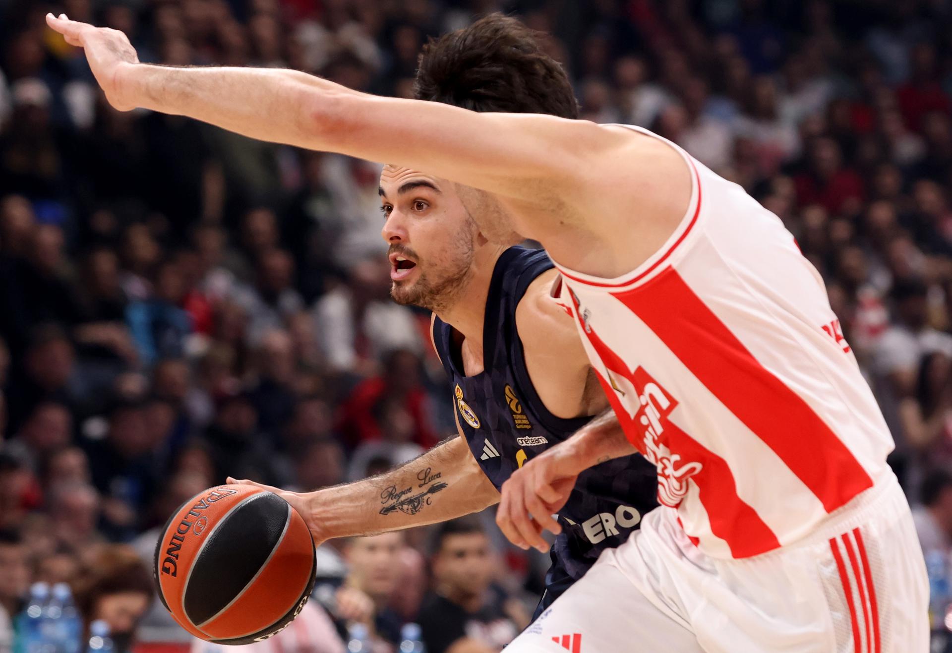 El jugador del Real Madrid Alberto Abalde (I) en acción ante Milos Teodosic (d) durante el partido de la Euroliga que han jugado en Belgrado, Serbia.
