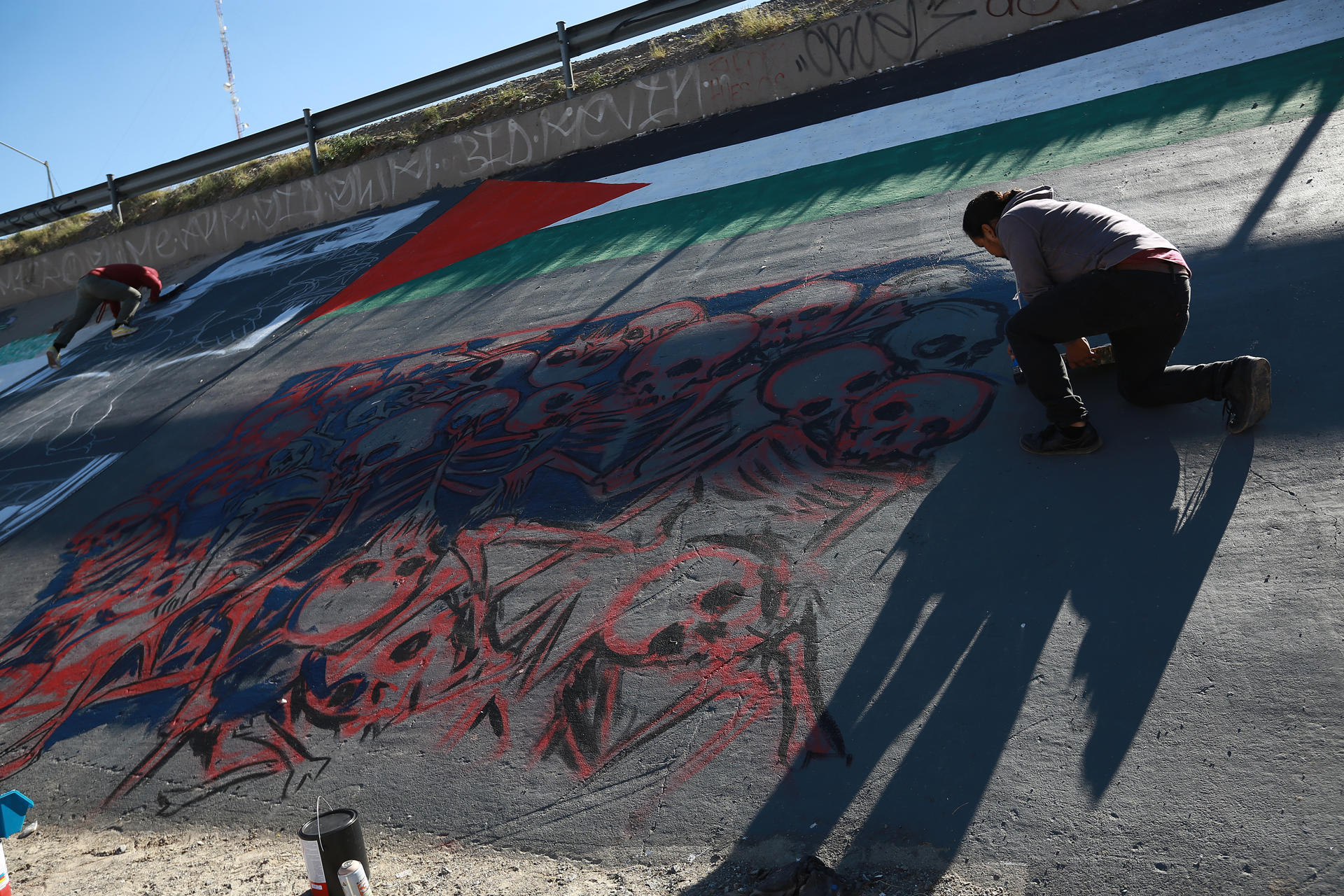 Activistas pintan un mural para denunciar la violencia de género y el maltrato a los migrantes, hoy junto al río Bravo en Ciudad Juárez, estado de Chihuahua (México). EFE/Luis Torres
