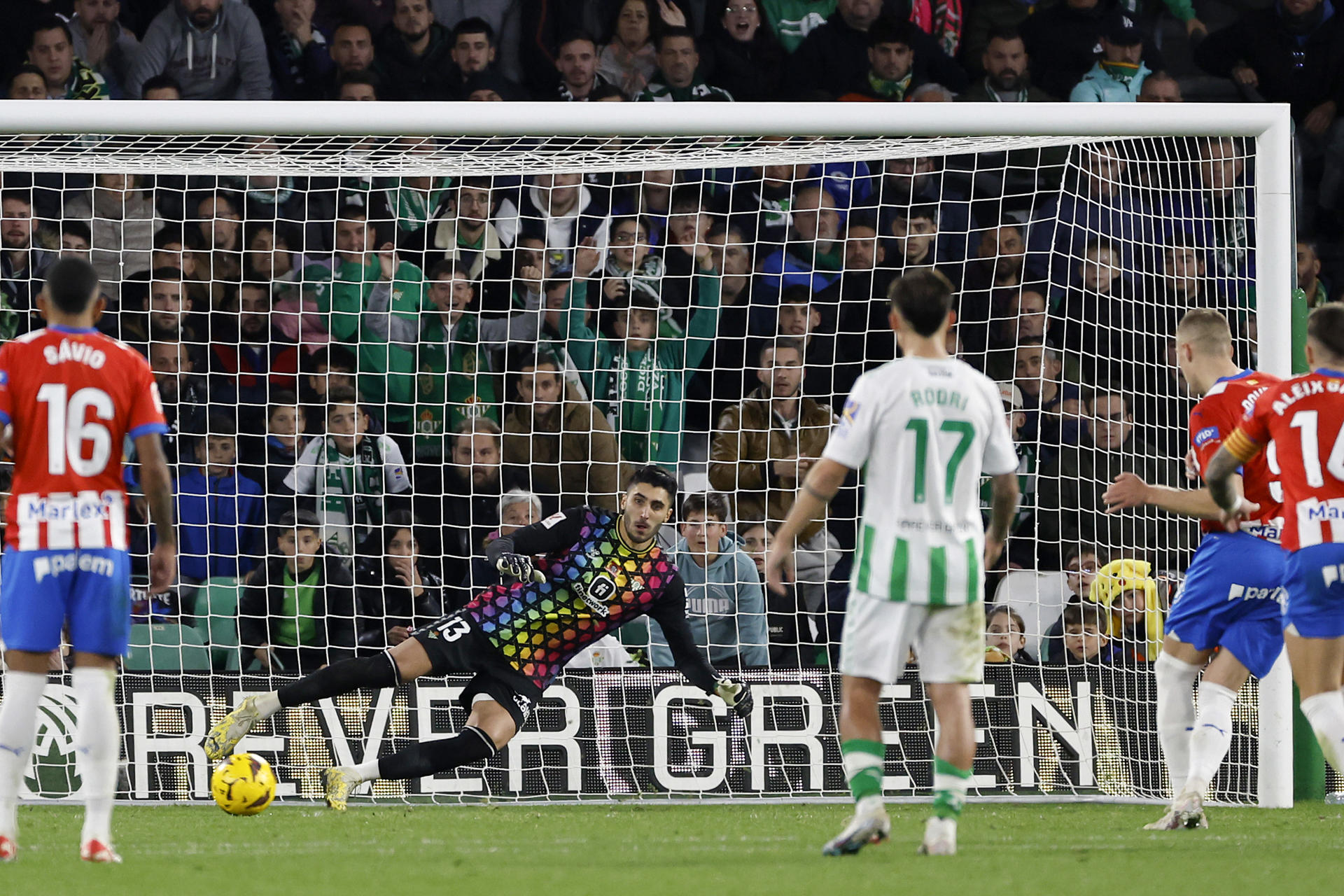 El portero del Real Betis Rui Silva (c) no puede detener el penalti lanzado por Artem Dovbyk (2d), del Girona FC, durante el partido de la Jornada 18 de LaLiga en el estadio Benito Villamarín de Sevilla. EFE/ Julio Muñoz
