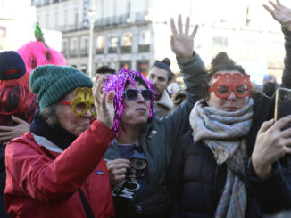 Varias personas celebran durante el ensayo de las campanadas de Fin de Año en la Puerta del Sol las 'preuvas'. EFE/ Víctor Lerena