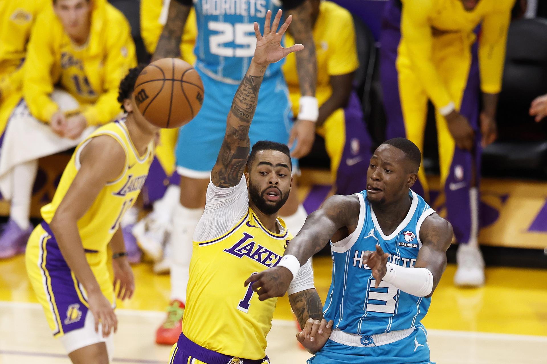 El jugador Charlotte Hornets Terry Rozier (d) pasa el balón a un compañero de equipo mientras está custodiado por D'Angelo Russell (i), de los Angeles Lakers durante el segundo cuarto del partido de la NBA entre Los Angeles Lakers y Charlotte Hornets en Los Ángeles, EFE/EPA/CAROLINE BREHMAN
