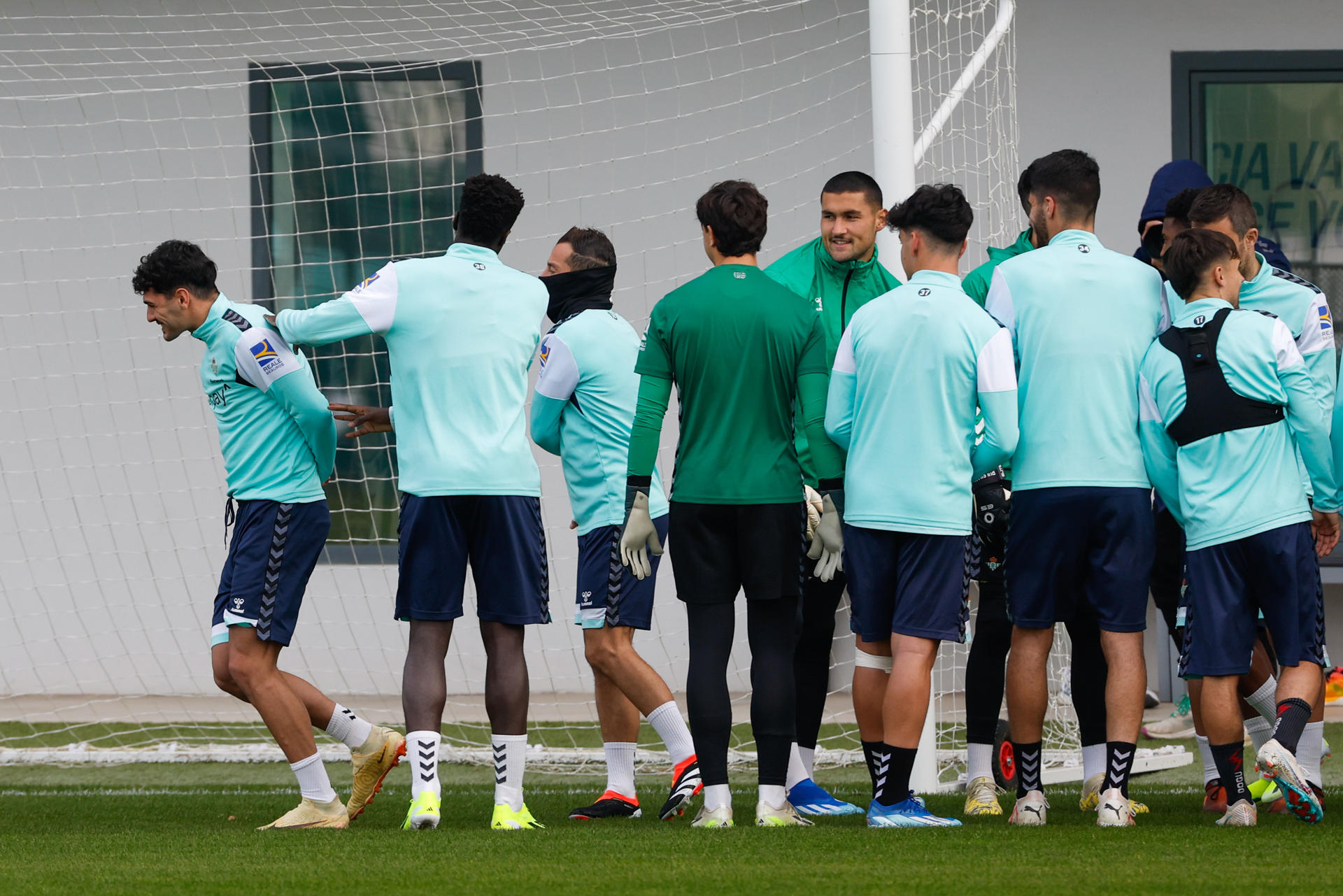 El centrocampista estadounidense Johnny Cardoso (izq) recibe la bienvenida de sus nuevos compañeros en el entrenamiento del equipo en la Ciudad Deportiva del club verdiblanco y bajo las órdenes del chileno Manuel Pellegrini. EFE/ Julio Muñoz
