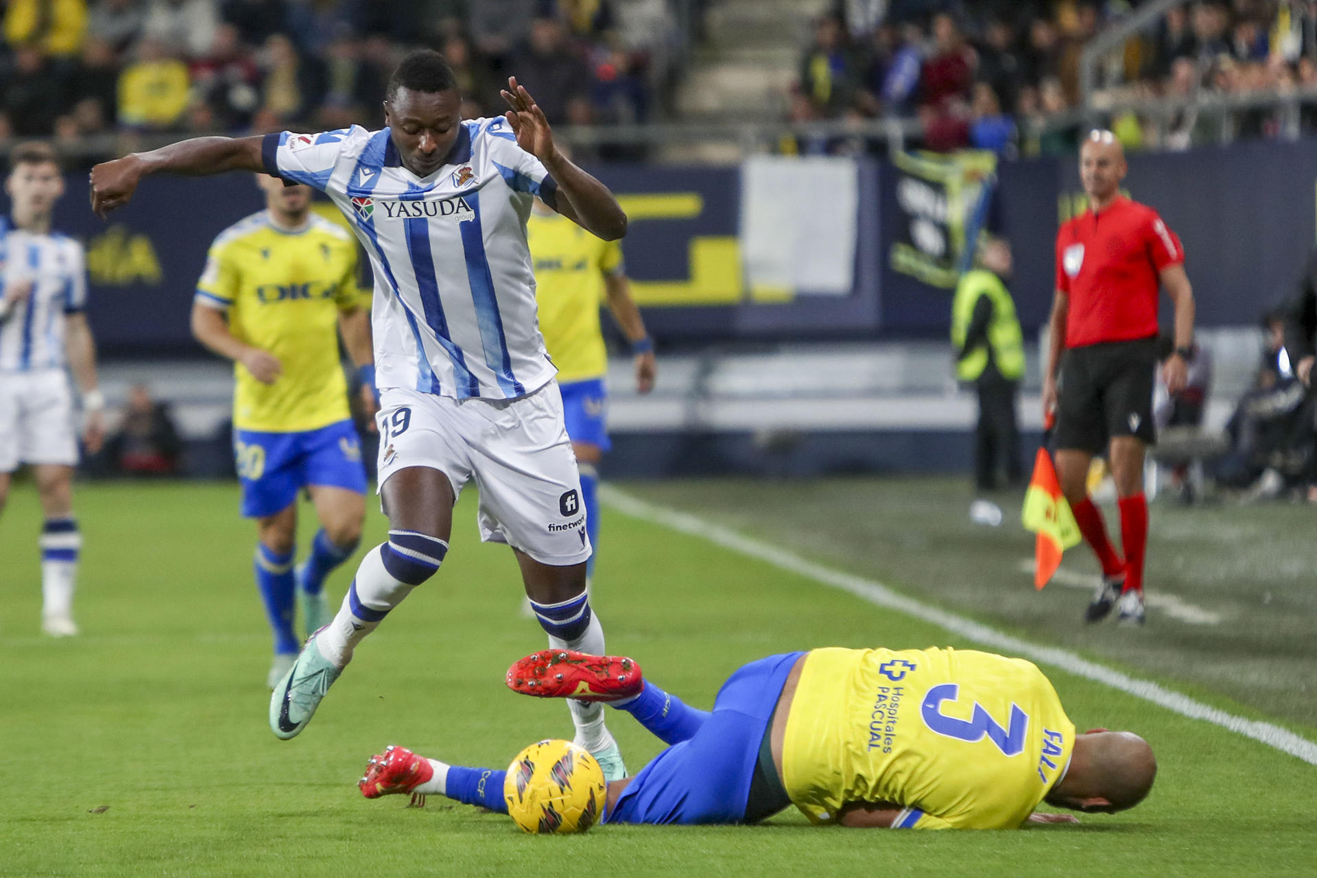 El delantero nigeriano del Real Sociedad, Sadiq Mesbah (i) lucha por el balón con el defensa del Cádiz CF, Fali, durante el partido de LaLiga en el Estadio Nuevo Mirandilla. EFE/Román Ríos.
