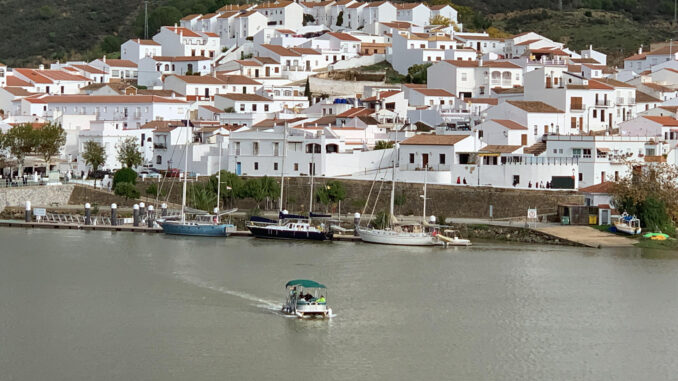 Vista de la localidad portuguesa de Alcoutim con la barca de la empresa ‘Fun River’, que todos los días del año hace el recorrido entre Alcoutim (Portugal) y Sanlúcar de Guadiana (Huelva) -al fondo-, un servicio que sobrevive con el paso de los años a pesar de que ya hay cuatro pasos por carretera para cruzar entre Andalucía, a través de la provincia onubense, y Portugal. Ninguno de los 400 habitantes de Sanlúcar de Guadiana, en Huelva, recuerda desde cuándo hay una barca que cruza el río para llegar a Alcoutim, su vecina portuguesa al otro lado del río, pero, en la era de la tecnología más avanzada, este servicio se mantiene igual que décadas e incluso siglos atrás, con un barquero que trabaja de sol a sol.-EFE/ Fermín Cabanillas
