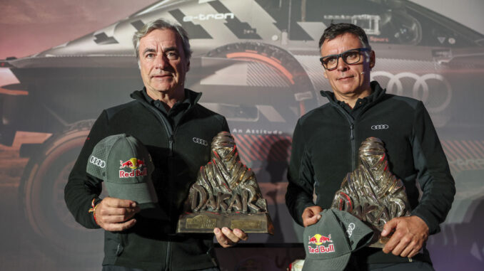 El piloto español Carlos Sainz (Audi) (i) junto a su copiloto Lucas Cruz comparecen ante la prensa tras llegar este sábado a Madrid, después de ganar por cuarta vez el Rally Dakar, prueba disputada en Arabia Saudi. EFE/Kiko Huesca
