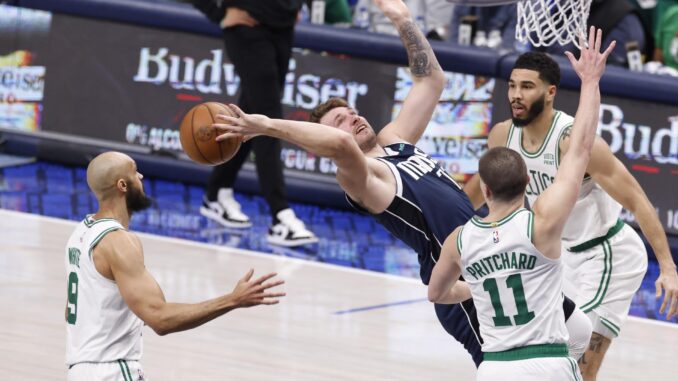 los jugadores de los Boston Celtics Derrick White (i), Payton Pritchard (2-d) y Jayson Tatum (d) alejan el balón del guardia de los Dallas Mavericks Luka Doncic de Eslovenia (2-i). EFE/EPA/ADAM DAVIS
