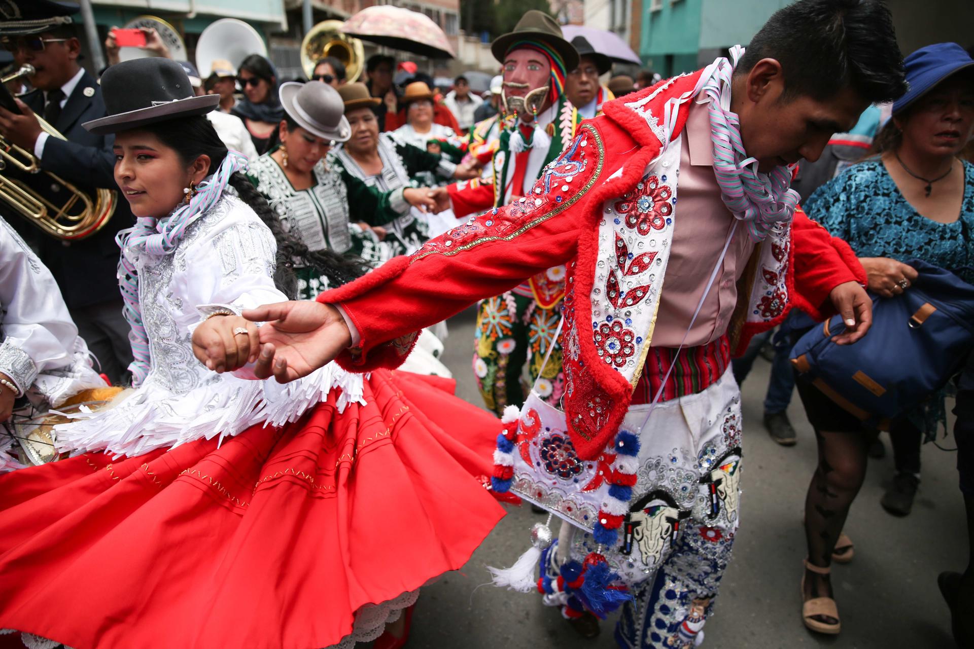 Una mujer aimara baila junto un hombre disfrazado de 'Chuta' durante el 'desentierro' de 'El Pepino', personaje principal del carnaval paceño, hoy, en La Paz (Bolivia). EFE/ Luis Gandarillas
