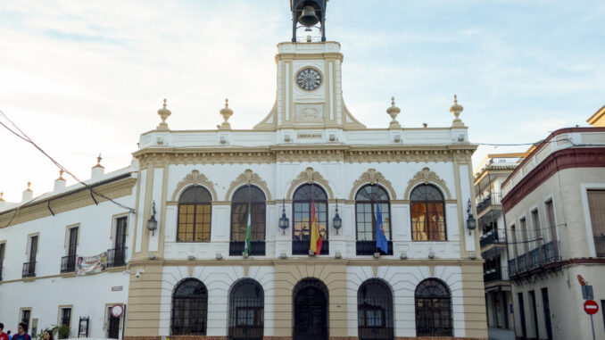 Vista del ayuntamiento de Morón de la Frontera, con las banderas a media asta por el fallecimiento de dos vecinos este jueves en Ciudad Real, cuando viajaban en coche a ver el partido del Sevilla contra el Atlético de Madrid de la Copa del Rey, en un accidente en cadena por la niebla en el que se han visto implicados numerosos camiones, turismos y furgonetas y en el que también ha muerto un camionero. En uno de los turismos implicados viajaban los aficionados sevillistas fallecidos, que son Antonio G.C., de 49 años, y su hijo Antonio G.M, de 17, mientras que su otro hijo menor está grave.-EFE/ David Arjona