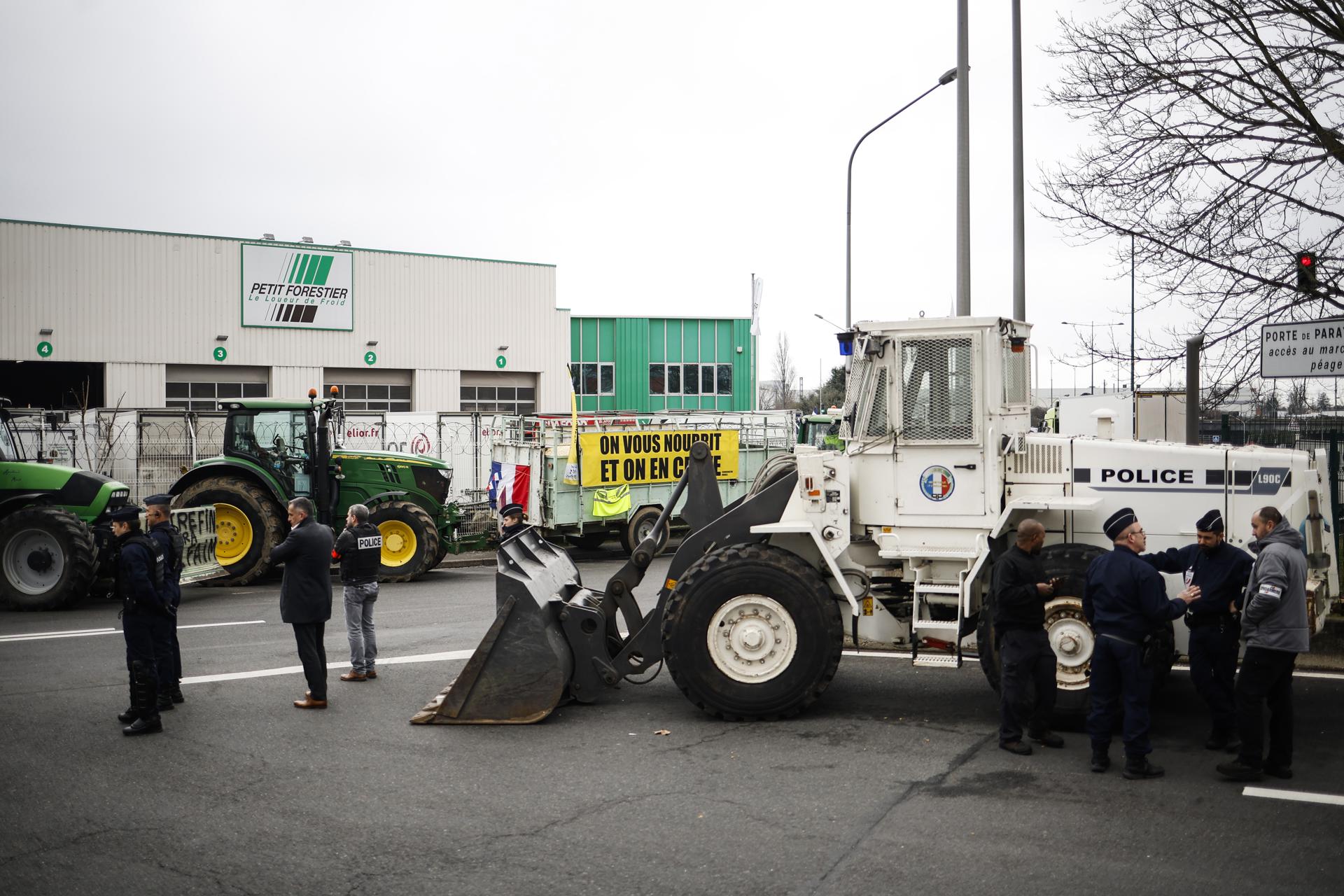 Agentes de policía se encuentran en la entrada del mercado internacional de Rungis, mientras los agricultores franceses llegaban con camiones para manifestarse, al sur de París, Francia, el 31 de enero de 2024. EFE/EPA/Yoan Valat
