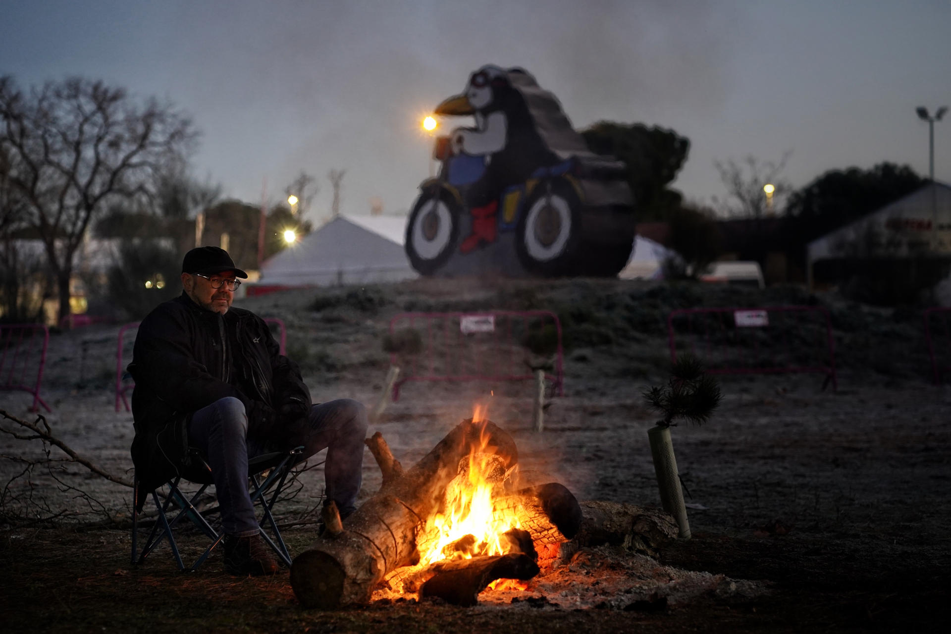 Un motorista se calienta en una hoguera durante el primer amanecer de la concentración motorista invernal internacional Pingüinos, que se celebra este fin de semana en Valladolid. EFE/Nacho Gallego
