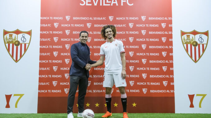 El presidente del Sevilla FC, José María del Nido Carrasco (i), estrecha la mano al centrocampista tunecino de 21 años Hannibal Mejbri, durante su presentación como nuevo jugador sevillista. EFE/ Raúl Caro.
