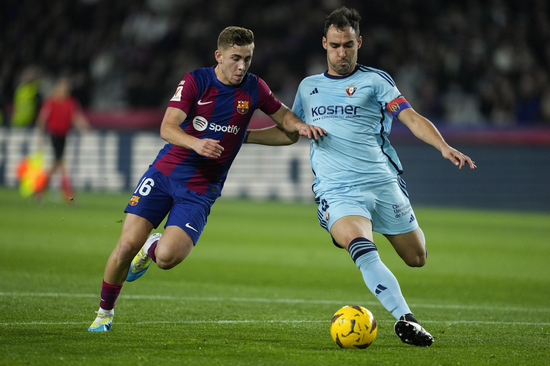 El centrocampista del Barcelona Fermín López (i) disputa el balón ante Unai García, defensa de Osasuna, durante el partido de la jornada 20 de LaLiga EA Sports entre FC Barcelona y CA Osasuna, este miércoles en el Estadi Olímpic Lluís Companys en Barcelona. EFE/ Enric Fontcuberta
