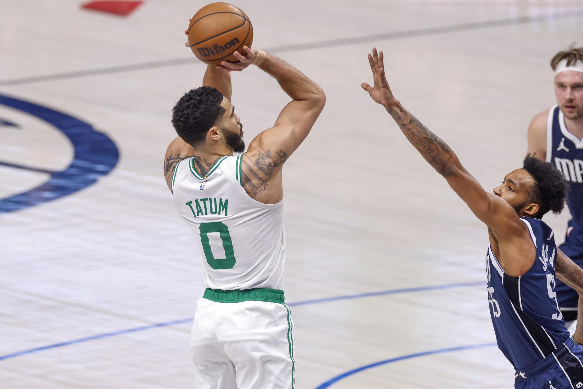 El jugador de los Celtics de Boston Jayson Tatum (i) toma un tiro sobre el delantero de los Mavericks de Dallas Derrick Jones Jr. (d) durante la primera mitad de un partido de la NBA. EFE/EPA/ADAM DAVIS
