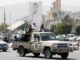 Simpatizantes hutíes viajan en un vehículo pasando junto a una pancarta que representa al máximo líder hutí, Abdul-Malik al-Houthi, en una calle de Saná, Yemen, en una fotografía de archivo. EFE/EPA/Yahya Arhab