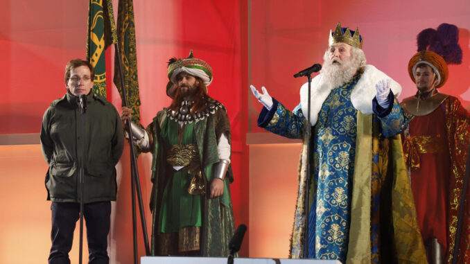 El alcalde de Madrid, José Luis Martínez-Almeida (i), escucha el discurso del Rey Melchor tras su llegada en la Cabalgata de los Reyes Magos, el pasado viernes en el centro de Madrid. EFE/ Zipi Aragón
