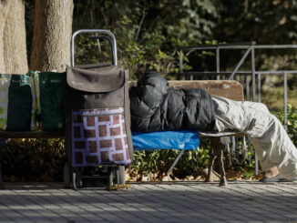 Una persona sin hogar descansa junto a sus pertenencias en un banco público. EFE/Ana Escobar