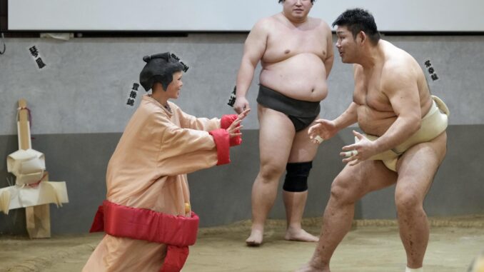 Vistiendo un traje de luchador de sumo, Fletcher (izq.), un turista australiano de 8 años, desafía al exluchador de sumo Jokoryu (dcha.) en un ring de sumo ante turistas extranjeros durante un almuerzo con espectáculo de sumo en el restaurante Yokozuna Tonkatsu Dosukoi Tanaka, en Tokio. EFE/EPA/FRANCK ROBICHON
