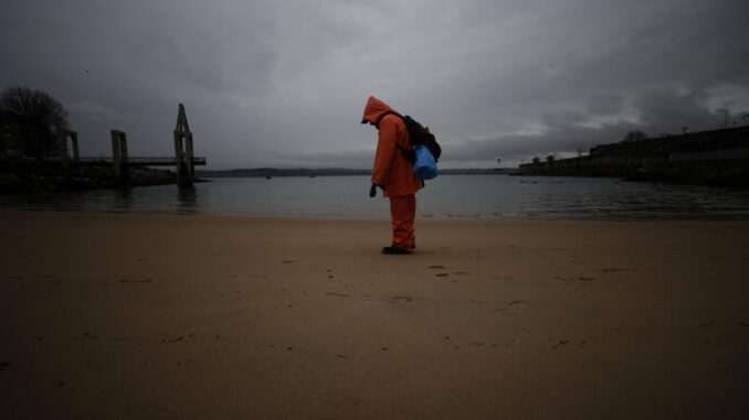 Continúa la recogida de pellets este martes en la playa de San Amaro, en la ciudad de A Coruña. EFE/Cabalar
