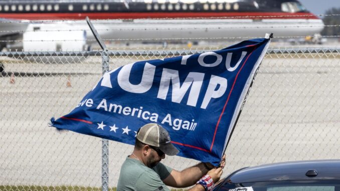 Un partidario del expresidente Trump sostiene una bandera frente al avión de Trump estacionado en el aeropuerto de West Palm Beach, Florida, EE.UU., el 29 de febrero de 2024. EFE/EPA/CRISTÓBAL HERRERA-ULASHKEVICH
