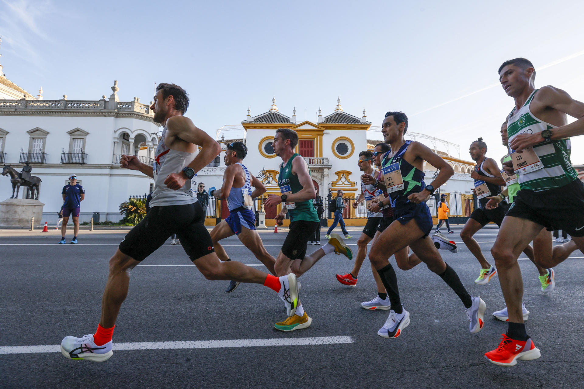 Corredores pasan por la Maestranza durante la Maratón de Sevilla, este domingo. EFE/ Jose Manuel Vidal
