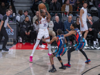 Kevin Durant (i) de los Suns busca a quien pasar el balón bajo la marca de los jugadores de los Nets Mikal Bridges (c) y Nicolas Claxton (d) hoy, durante un partido de baloncesto de la NBA entre Brooklyn Nets y Phoenix Suns, disputado en el pabellón deportivo multiusos Barclays Center en el barrio de Prospect Heights, Brooklyn, Nueva York (EE.UU.). EFE/ Ángel Colmenares