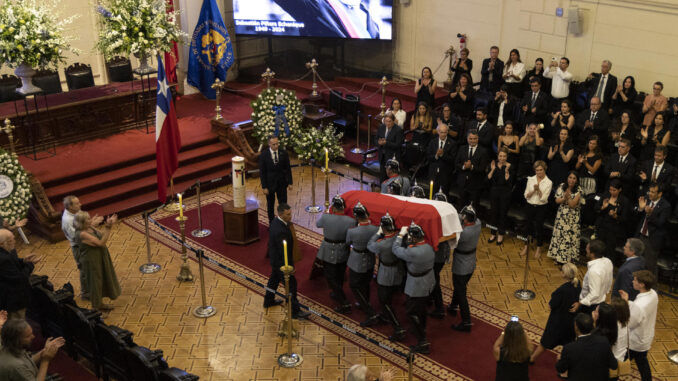 Agentes sostienen el ataúd con el cuerpo del expresidente de Chile Sebastián Piñera hoy, en la antigua sede del Congreso en Santiago (Chile). EFE/Ailen Díaz
