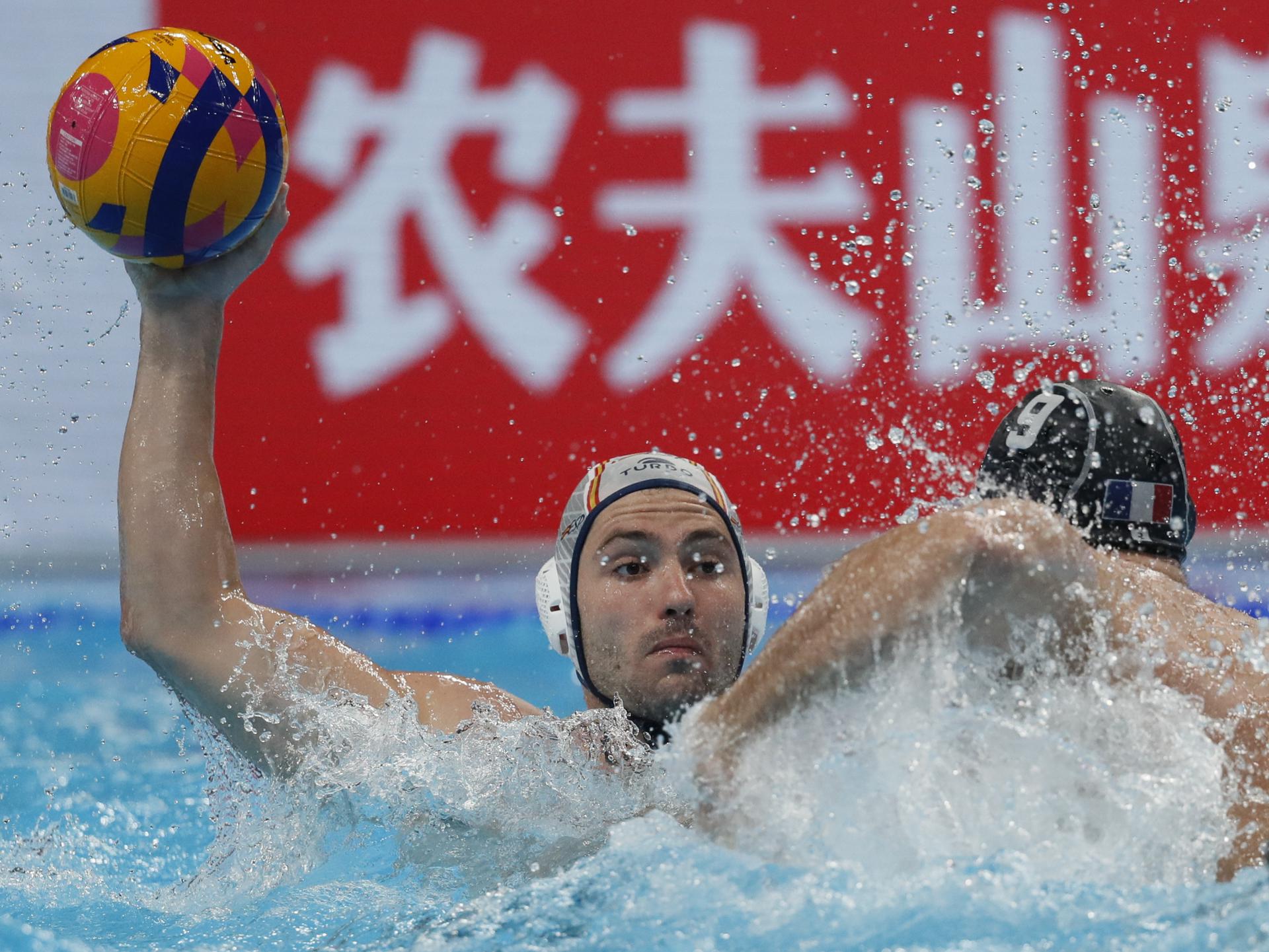 El español Alberto Muñárriz (i) trata de superar al francés Duje Zivkovic, durante el partido por el tercer puesto de waterpolo en los Mundiales de Doha. EFE/EPA/YURI KOCHETKOV
