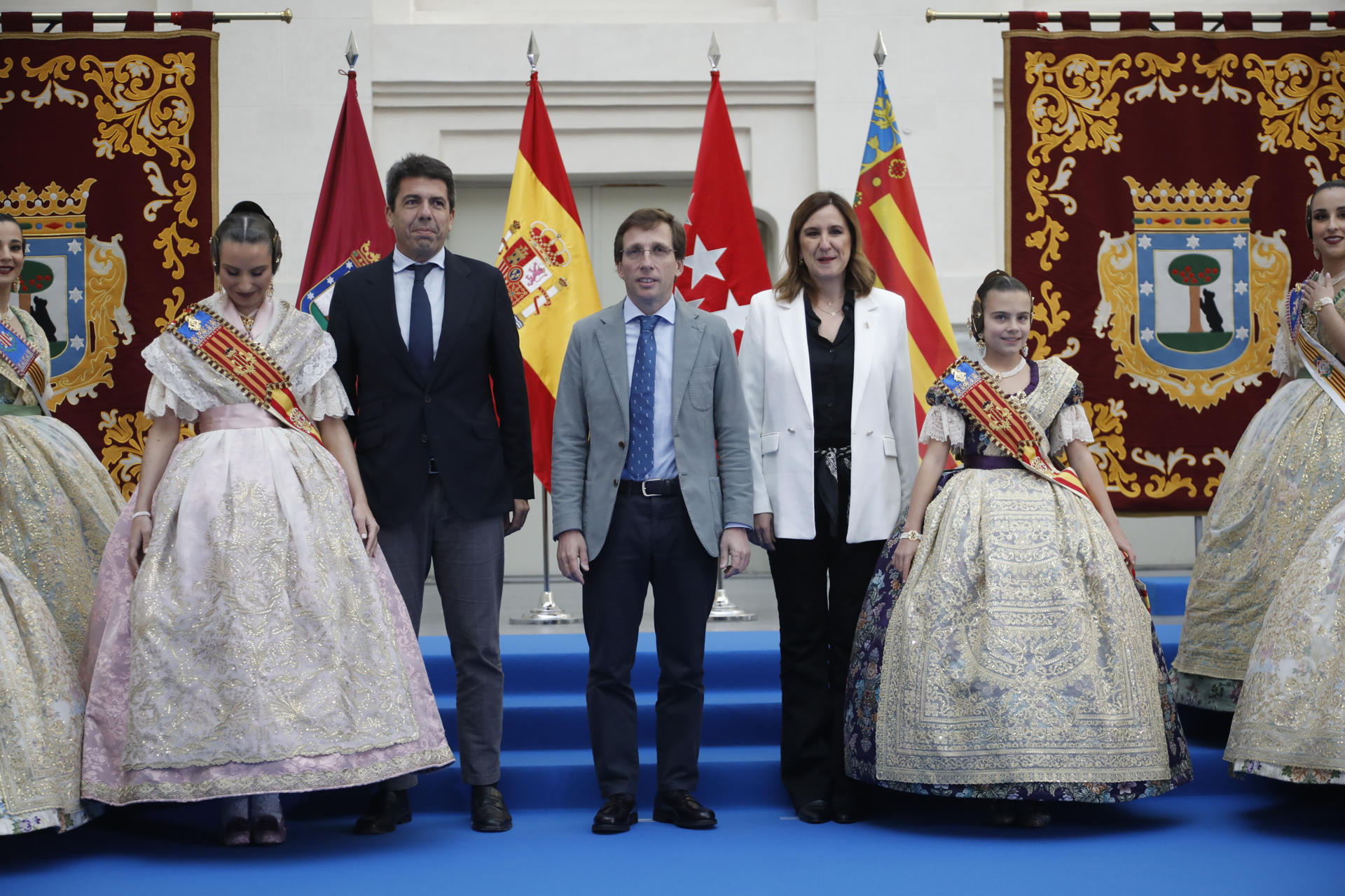 El alcalde de Madrid, Jose Luis Martínez Almeida (c), recibe a la alcaldesa de Valencia, María José Catalá (c-d), y al presidente de la Comunidad Valenciana, Carlos Mazón(c-i), junto a las falleras mayores de Valencia, acompañadas por sus cortes de honor este domingo en el Palacio de Cibeles de Madrid, antes de la Mascletá que tendrá lugar en el Puente del Rey, en la zona de Madrid Río. EFE/David Fernández
