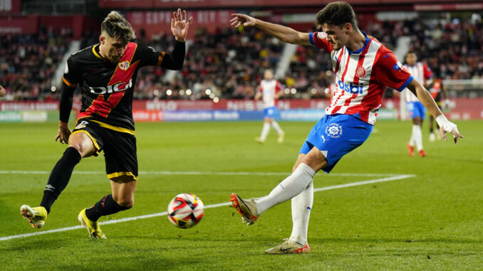 El defensa del Girona Miguel Ortega Gutiérrez (d) dispara junto al rumano Andrei Ratiu, del Rayo Vallecano en el Estadio Municipal de Montilivi, en Girona en foto de archivo de Siu Wu.EFE
