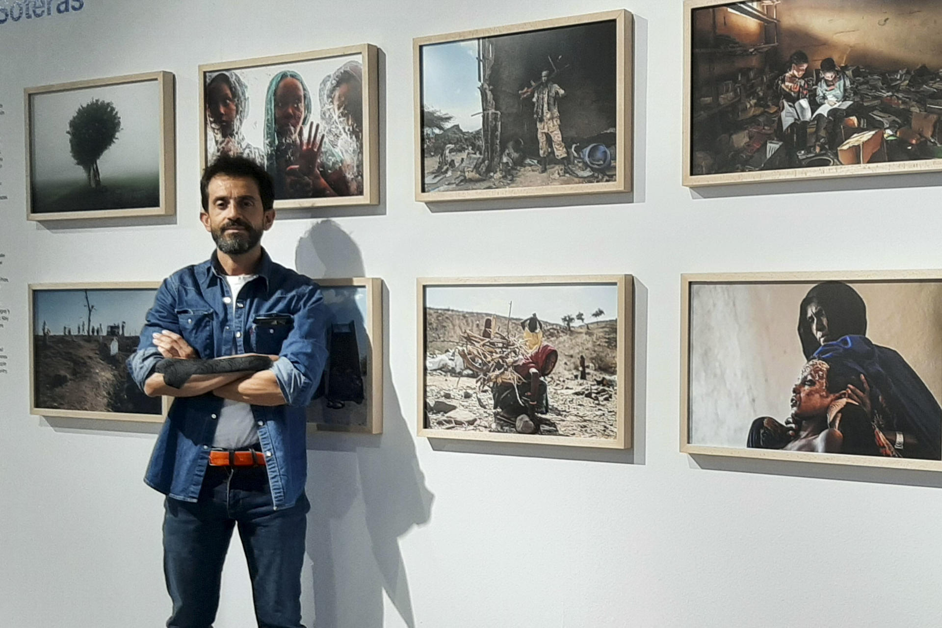 El fotógrafo argentino Eduardo Soteras posa para EFE junto a varias de las imágenes que conforman su exposición 'Tigray. Cascading into Chaos', en Madrid. EFE/ Rosa Díaz
