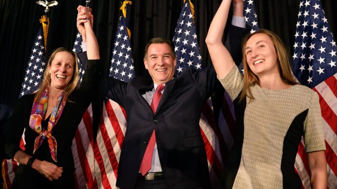 El congresista electo Tom Suozzi (c), su esposa Helene (i) y su hija Caroline (d), saludan a la multitud después de ganar las elecciones especiales para el tercer distrito del Congreso de Nueva York. EFE/EPA/Peter Foley
