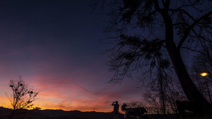 Un hombre fotografía el cielo este miércoles al amanecer en San Sebastián. EFE/Javier Etxezarreta
