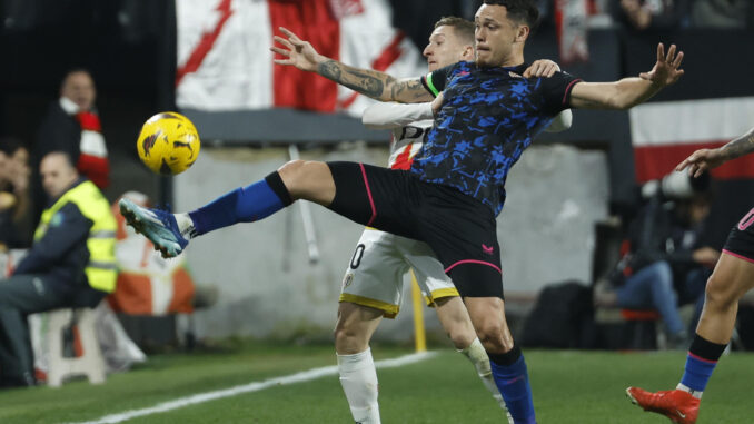 Imagen de archivo del jugador argentino del Sevilla FC, Lucas Ocampos (delante), peleando por el balón con el jugador albanés del Rayo Vallecano, Iván Balliu, durante el partido de la jornada 23 de LaLiga EA Sports, disputado en el estadio de Vallecas, en Madrid. EFE/Juanjo Martín
